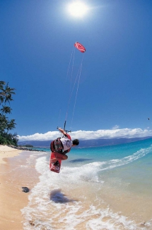 Kitesurfer skimming sandy beach [photo] - Kitesurfing