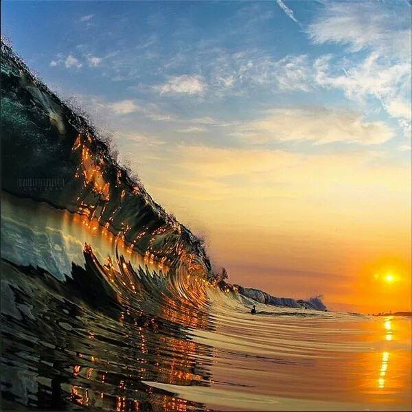 Stunning photo of the sunset reflecting of a glassy wave